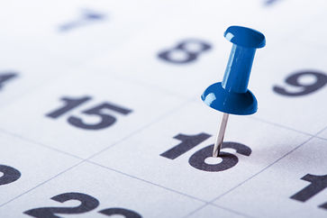 Detailaufnahme eines Kalenderblattes mit blauem Pin auf einem Datum